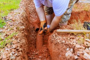 Man fixing collapsed sewer line